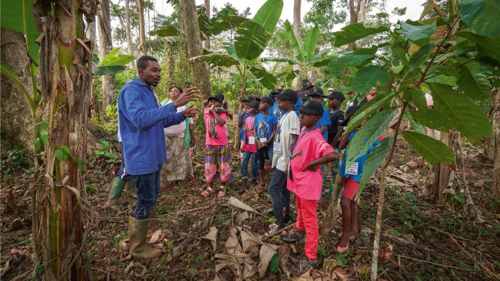 ného způsobu využívání lesa a pěstování plodin. Foto: At one of the Wandering Bus stops – the organic farming base in Kabilon II – children learn about the possibilities of sustainable forest use and crop cultivation. Photo: Khalil Baalbaki, Prague Zoo.